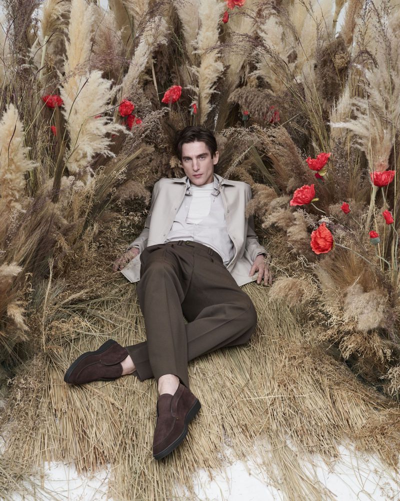 Anatol Modzelewski reclines in brown suede loafers for Santoni's spring-summer 2024 campaign.