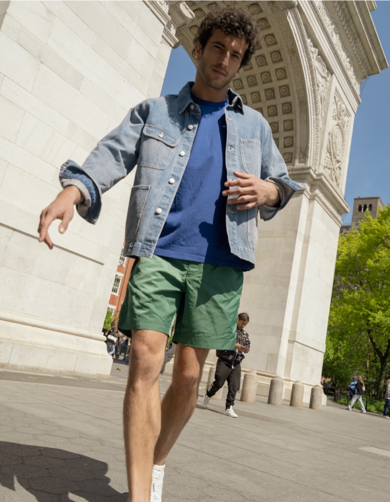 Mixing colors, Raphael Diogo goes casual in Alex Mill's denim work jacket, nylon shorts, and slub cotton t-shirt.