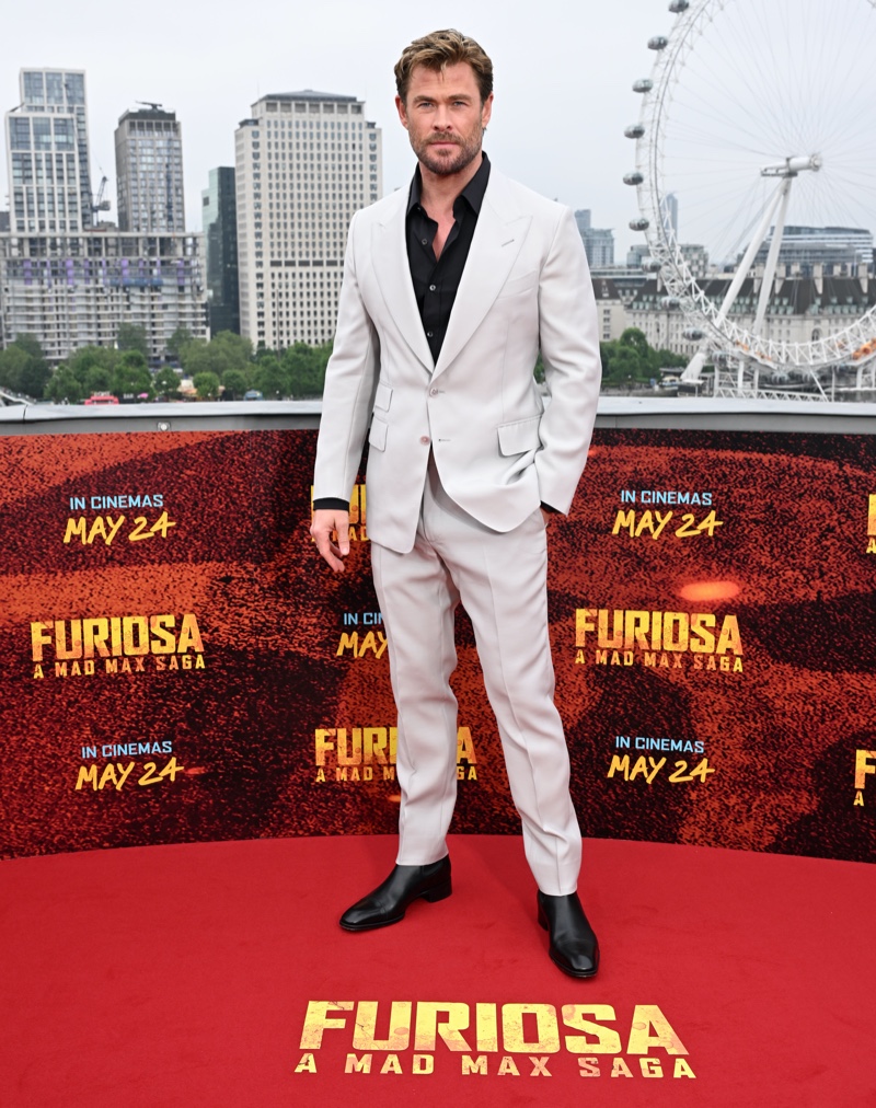 Chris Hemsworth wears a Tom Ford suit with leather boots to the Furiosa: A Mad Max Saga photocall in London.