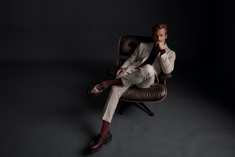 Model Jason Morgan reclines in a pair of burgundy dress socks by FALKE.