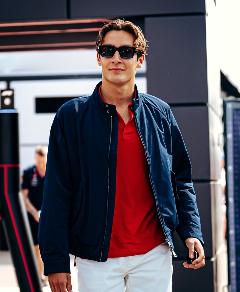 Embracing classic sportswear, George Russell wears Tommy Hilfiger's Portland jacket with a red polo and white jeans at the Emilia Romagna Grand Prix.