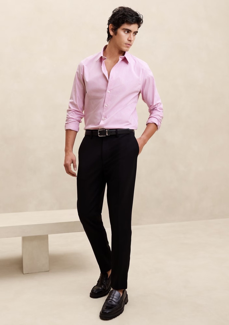 A pink dress shirt paired with black trousers creates a polished look.