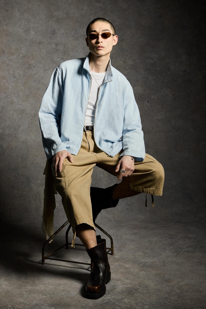 Model Sang Woo Kim dons a zippered, striped overshirt and long cargo shorts. 