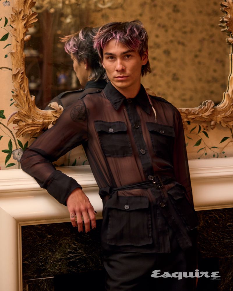 Standing before an ornate mirror, Evan Mock dons a sheer shirt by Saint Laurent for Esquire Australia. 