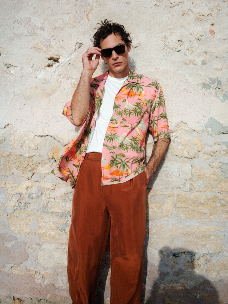 Pierre-Benoit Talbourdet embraces a tropical style with a pink palm print shirt and terracotta trousers from GANT's summer 2024 collection.