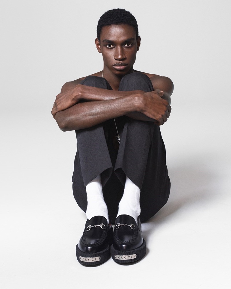 Modou Wade wears sleek black loafers with classic white socks for Gucci's fall-winter 2024 campaign.
