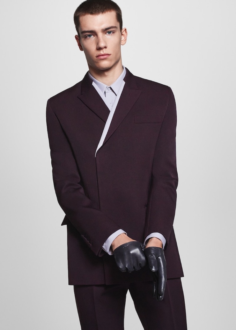 Emilio Cilia dons a tailored dark plum suit with leather gloves for Gucci's fall-winter 2024 campaign. 