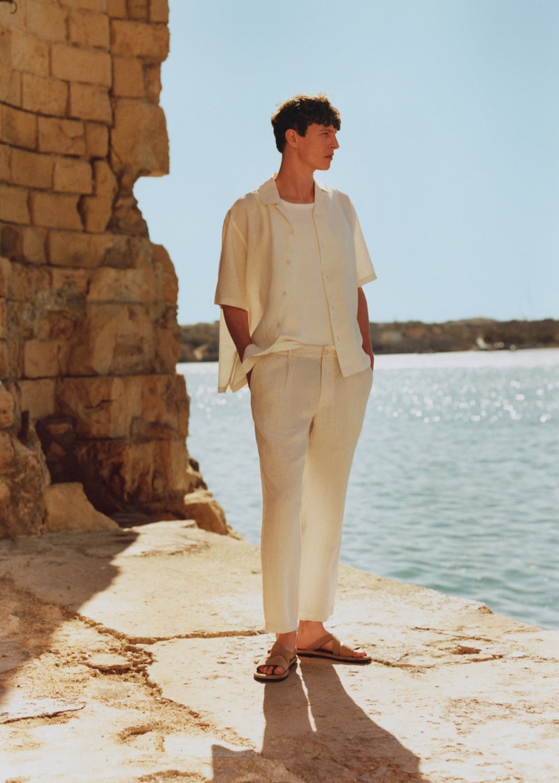 Tim Schuhmacher takes in the Malta seascape in a cream-colored outfit, part of Mango's summer 2024 collection. 