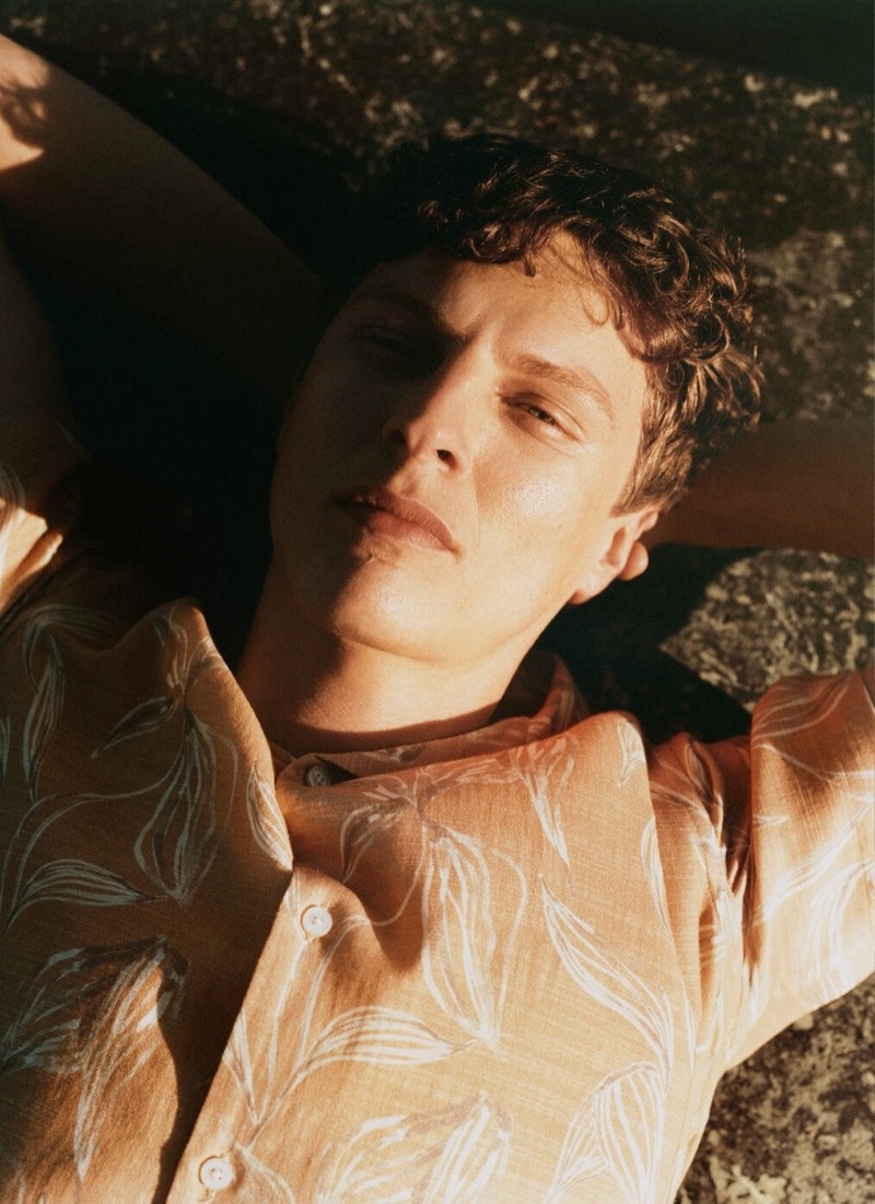 Lounging under the sun, Tim Schuhmacher showcases a patterned shirt, capturing the essence of Mango’s summer 2024 collection.