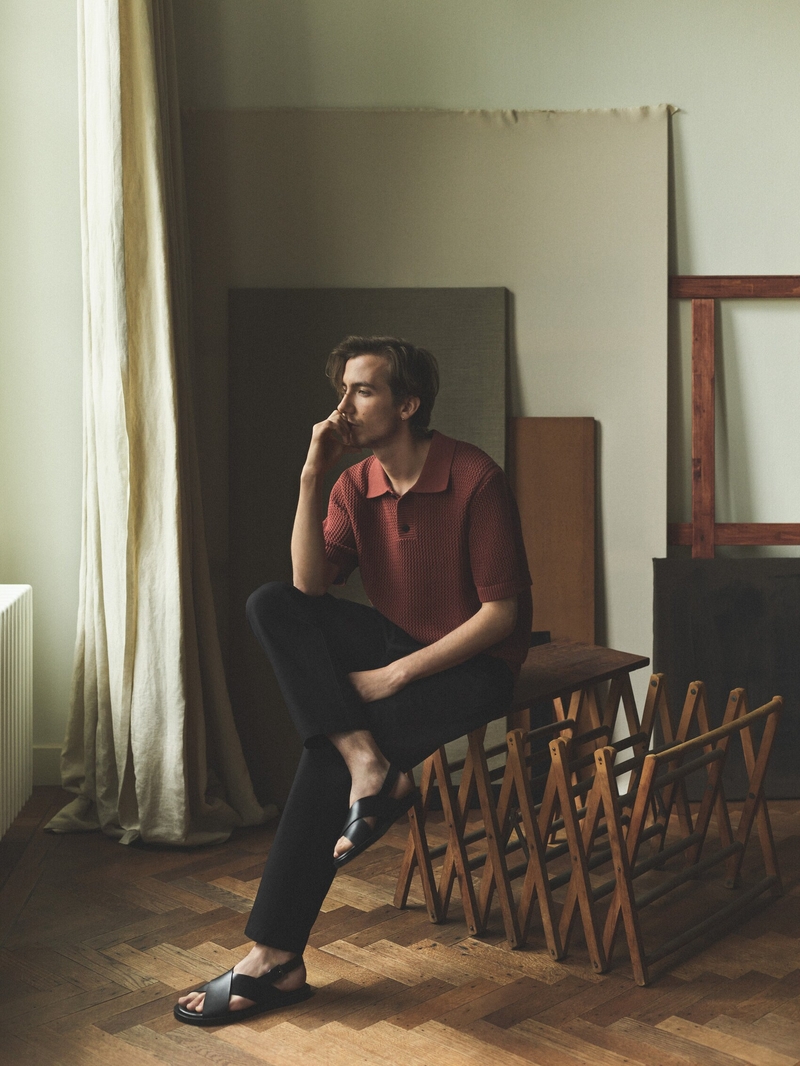 Connecting with Massimo Dutti, Paul Hameline sports a waffle texture polo and black trousers.