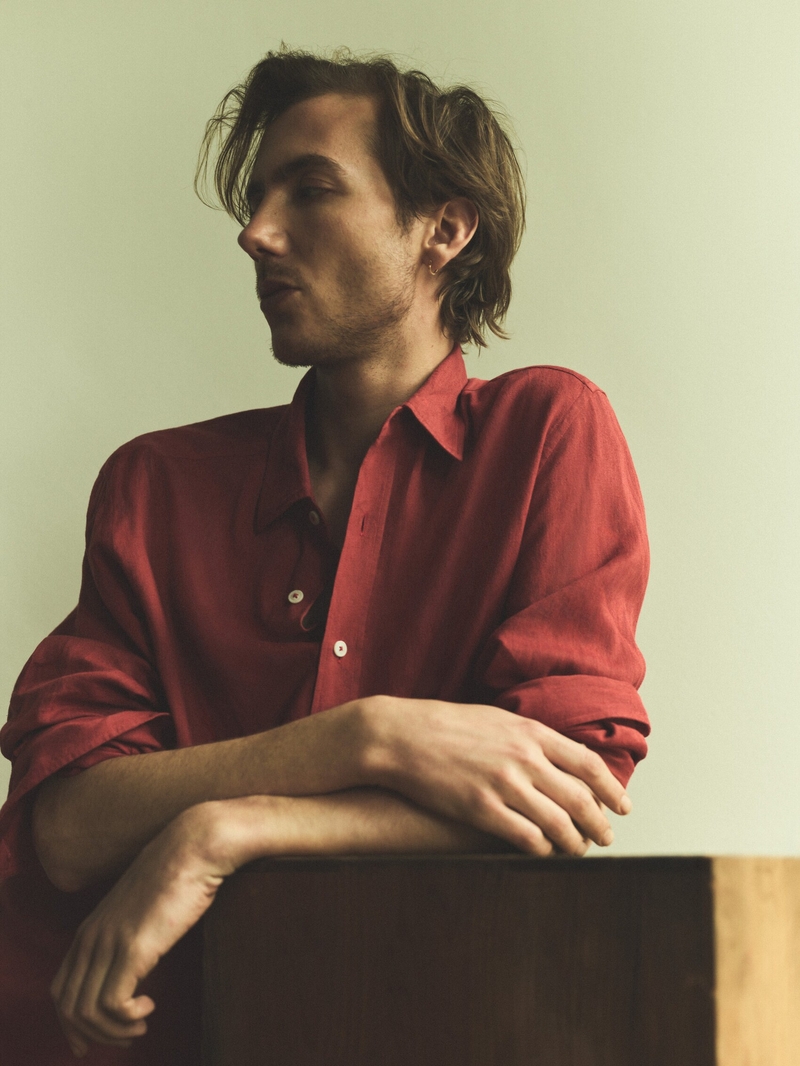 A vibrant red shirt and a contemplative pose mark Paul Hameline's sophisticated look for Massimo Dutti.