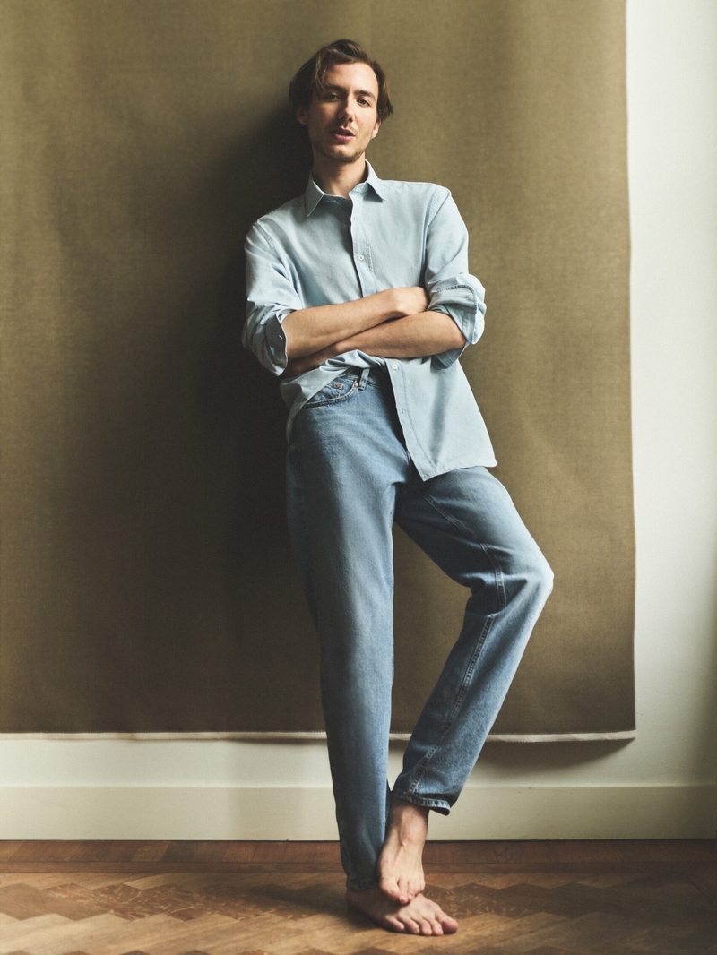 Paul Hameline wears a casual look from Massimo Dutti, pairing a light blue shirt with relaxed denim jeans.
