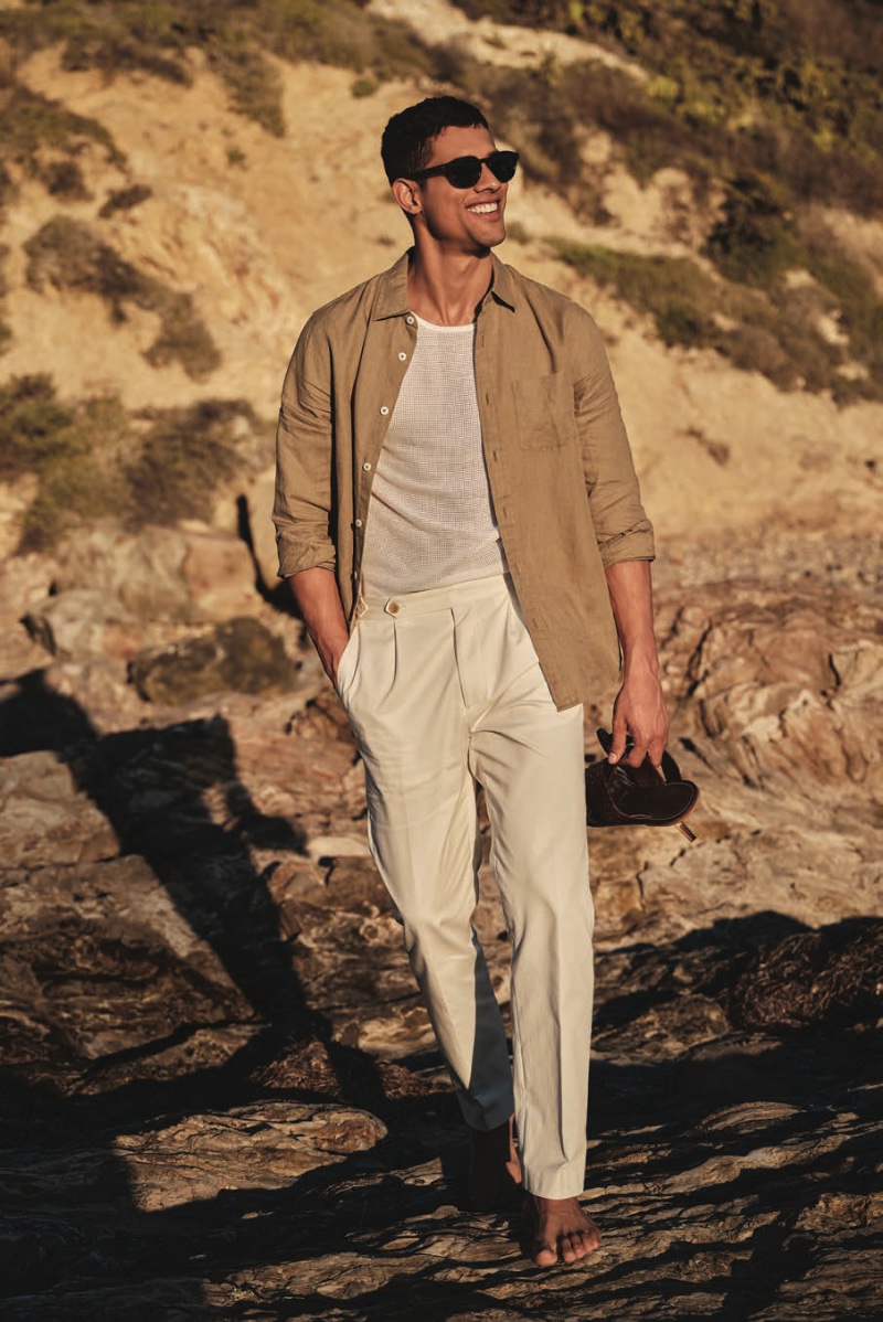 Jonas Barros strolls along a sunlit shore in Todd Snyder's lightweight cotton side-tab trousers and luxe mesh tank with a slim-fit Sea Soft Irish linen shirt.