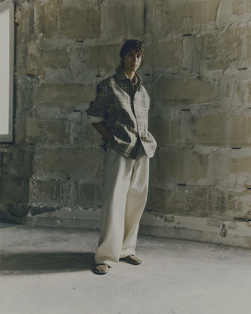 Saul Symon showcases casual sophistication in a plaid jacket and wide trousers from AMI’s spring-summer 2025 collection.