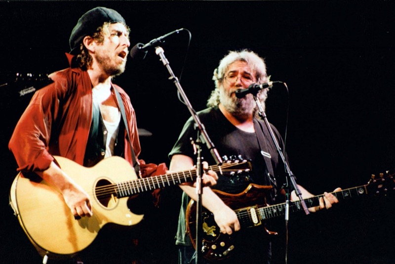 Performing with The Grateful Dead in 1987, Bob Dylan amplifies his layering with a vest and red shirt, accessorized with a beret.