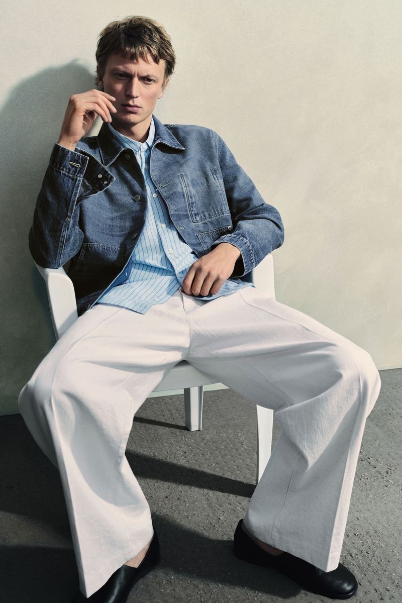 Model Jonas Glöer rocks a denim jacket with pleated wide-leg denim trousers.