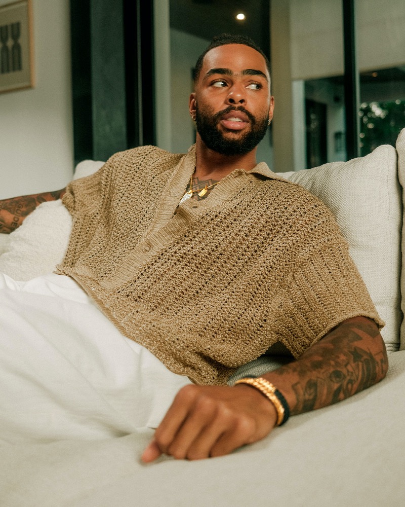 D’Angelo Russell of the L.A. Lakers lounges effortlessly in a loose-knit top, showcasing David Yurman’s gold jewelry.