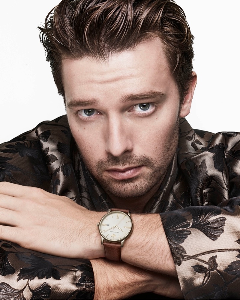 Patrick Schwarzenegger dons a brown leather watch for Emporio Armani’s summer 2024 accessories campaign.