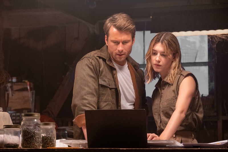 Concentration fills the room as Glen Powell and Daisy Edgar-Jones analyze crucial data, their characters, Tyler and Kate, deep in planning in “Twisters.”