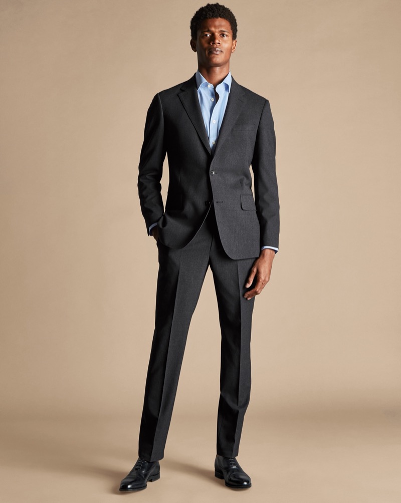 Command the room in a charcoal grey suit complemented by a light blue shirt. 