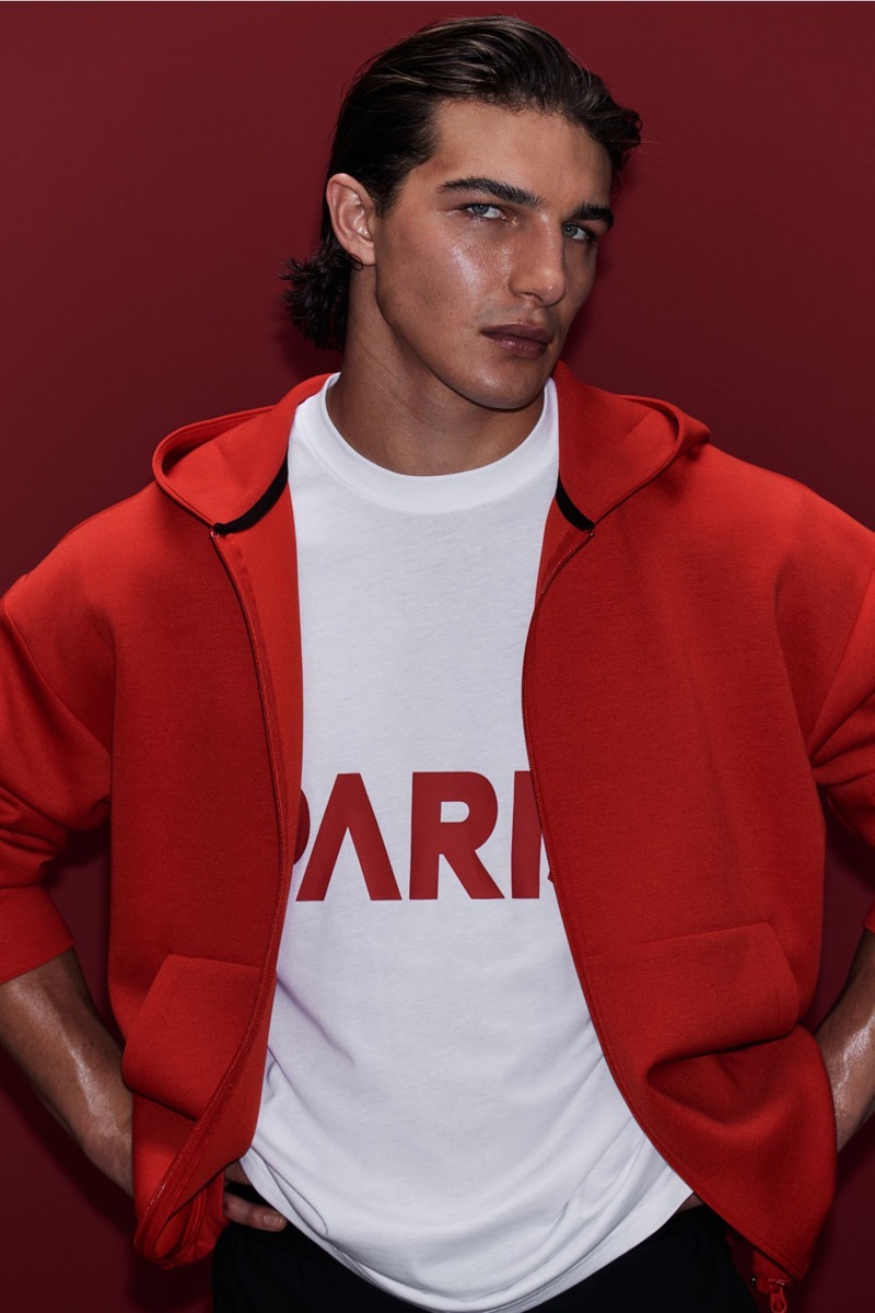 Making a bold, sporty statement, Sacha Bilal rocks a red hooded jacket.