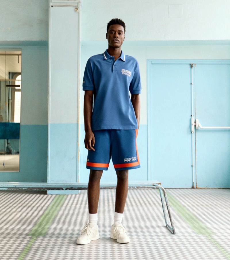 Babacar N’doye sports a blue polo shirt and shorts from the Lacoste Heritage Paris 1924 collection.