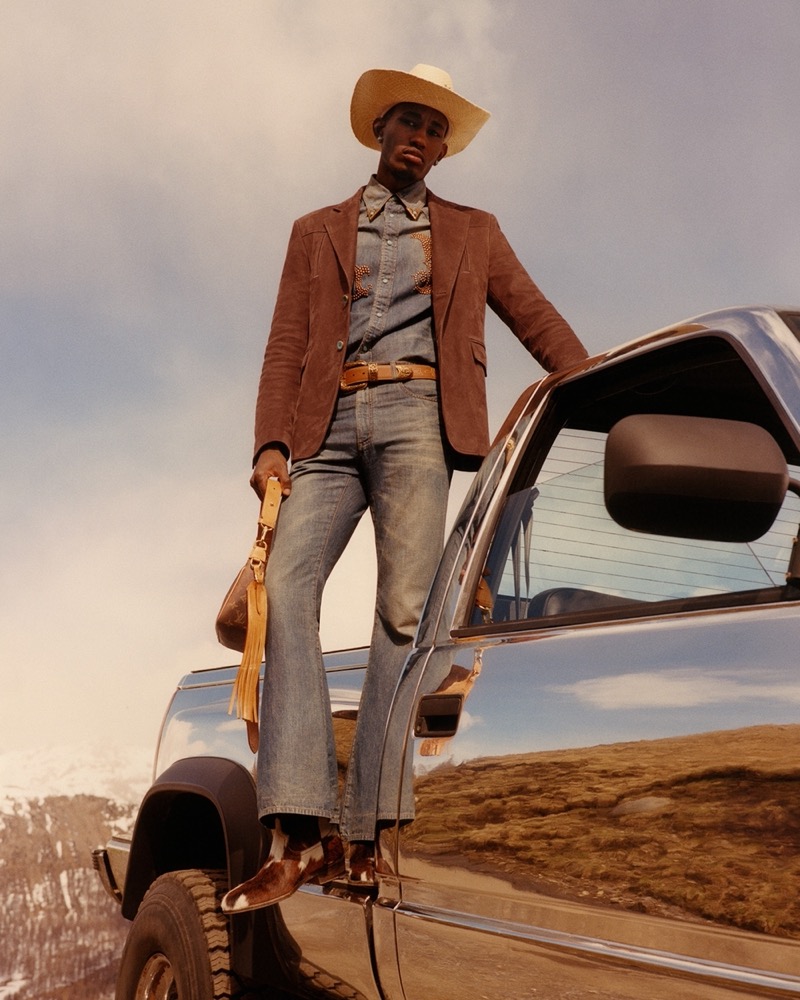 Standing tall on a truck, Rayan Lamarre epitomizes rugged elegance in double denim and a suede jacket for the Louis Vuitton fall-winter 2024 campaign.