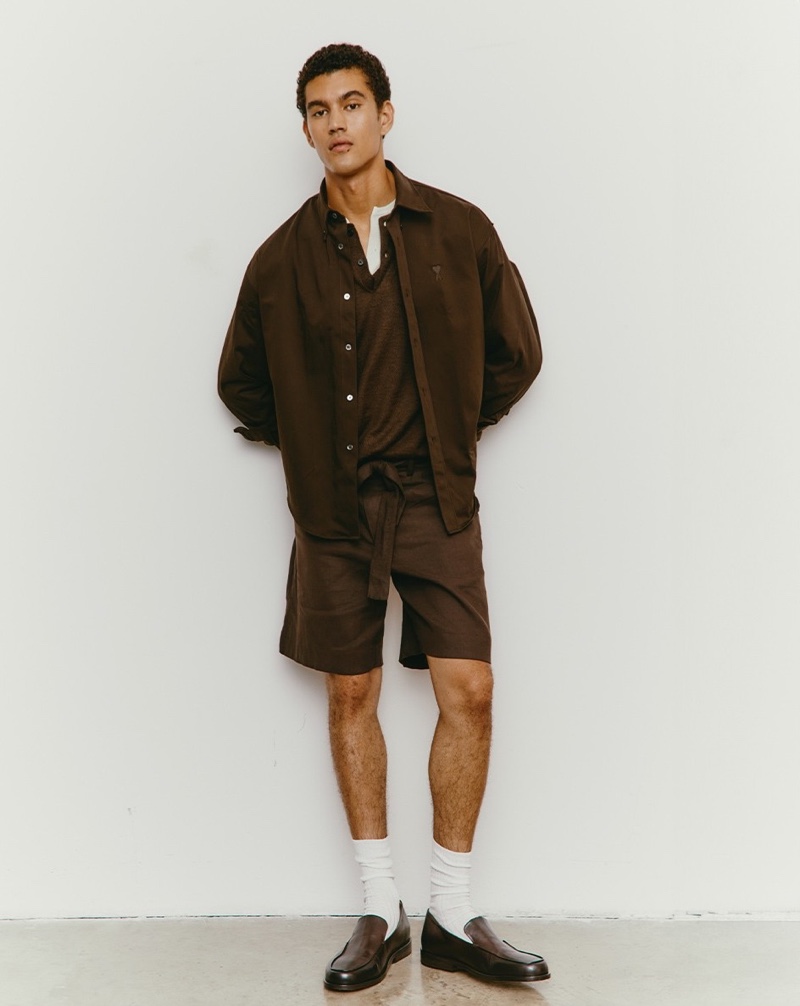 Sporting a brown outfit, Bodhi Heeck dons an AMI shirt with Commas shorts, an Auralee henley, and Marsell loafers.