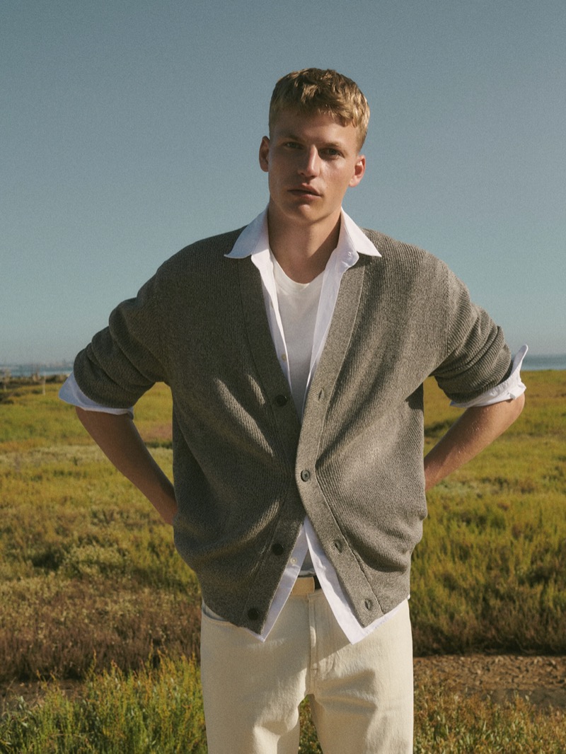 Timo Pan models a cardigan layered with a classic white shirt. 