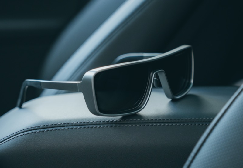 Sleek and modern, the Porsche Design Iconic Curved P8952 sunglasses rest stylishly on a leather car armrest.