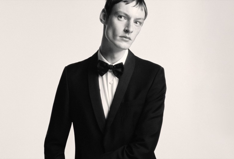 Matthew Seymour embodies classic sophistication in Prada’s Made to Measure advertisement, showcasing a timeless black tuxedo with a sharp bow tie.