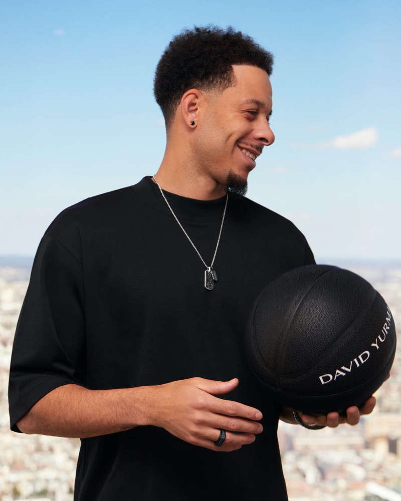 Seth Curry of the Charlotte Hornets radiates a relaxed vibe in a black tee, complemented by David Yurman’s sleek dog tag necklace.