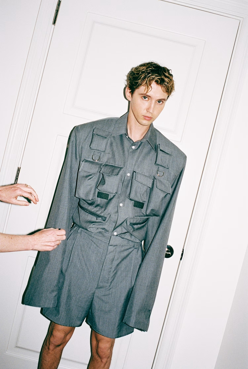 Troye Sivan stars in an SSENSE feature, wearing a Prada shirt and shorts. 