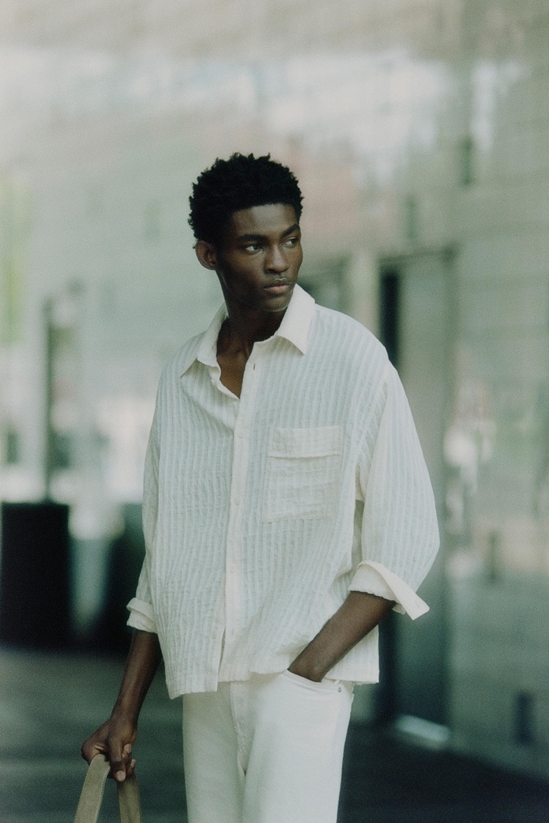 Evans Ikechukwu wears a light yellow shirt and white jeans from Zara.