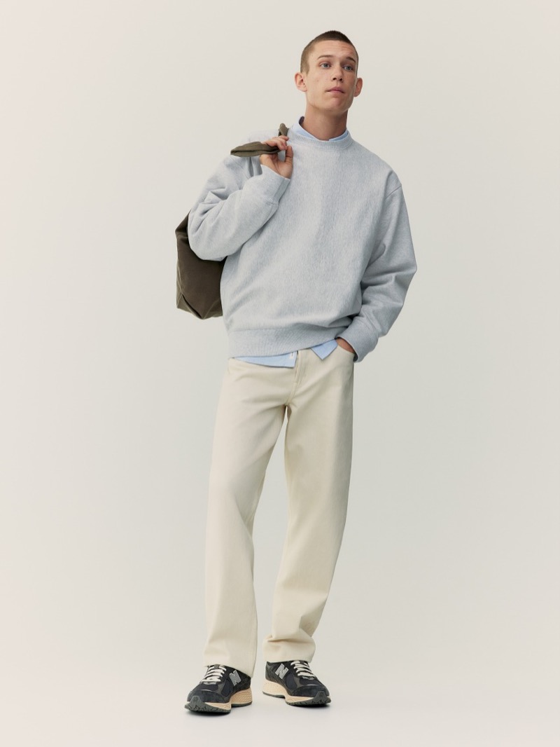 Classic, smart style is front and center with an ARKET sweater and ecru-colored jeans.