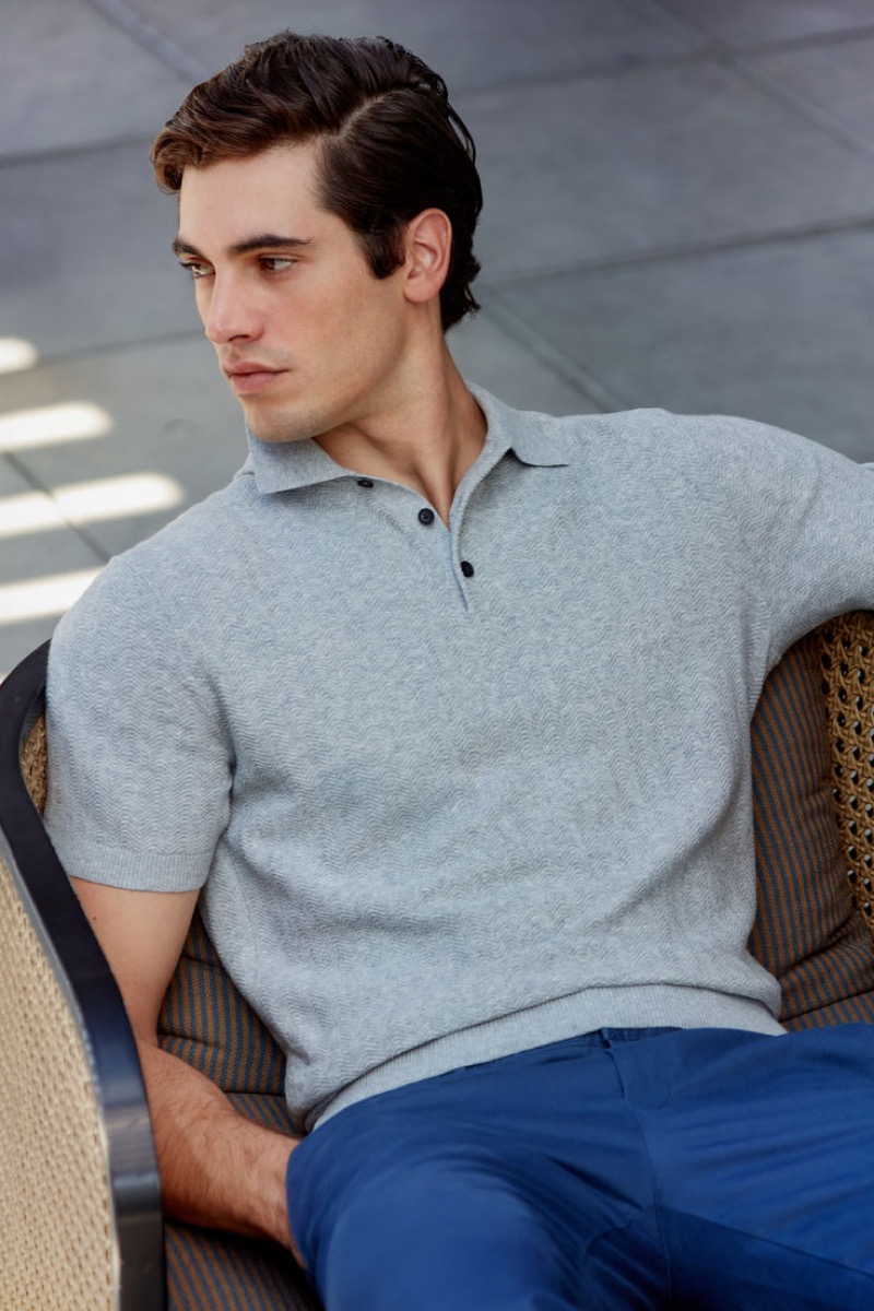 Model Marco Bellotti sports a textured short-sleeve polo sweater by Club Monaco.