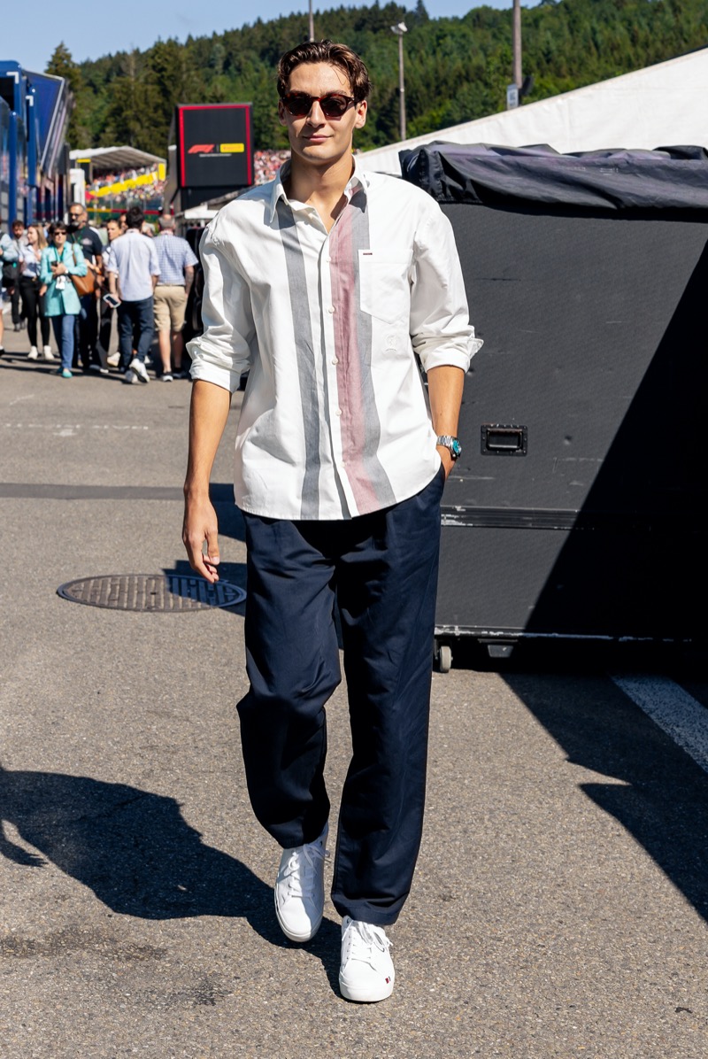 Polishing up his style in Tommy Hilfiger, George Russell dons an Oxford shirt with navy chinos and white sneakers. 