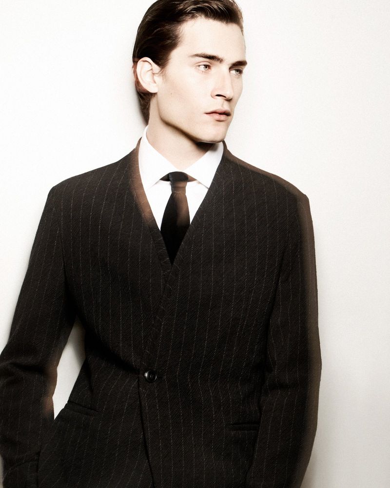 Liam Kelly models pinstripe tailoring for Giorgio Armani’s fall-winter 2024 campaign.