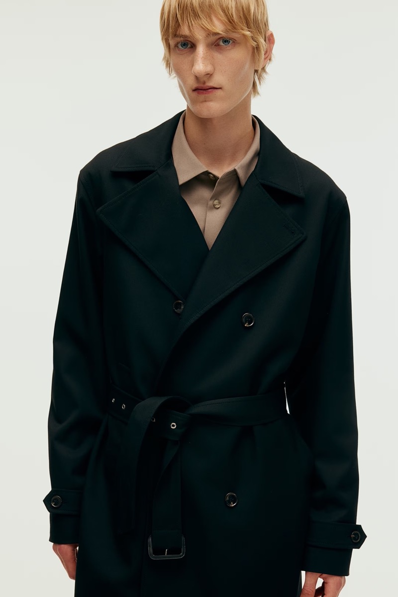 Model Pierrick Grégoire dons a black trench coat from H&M. 