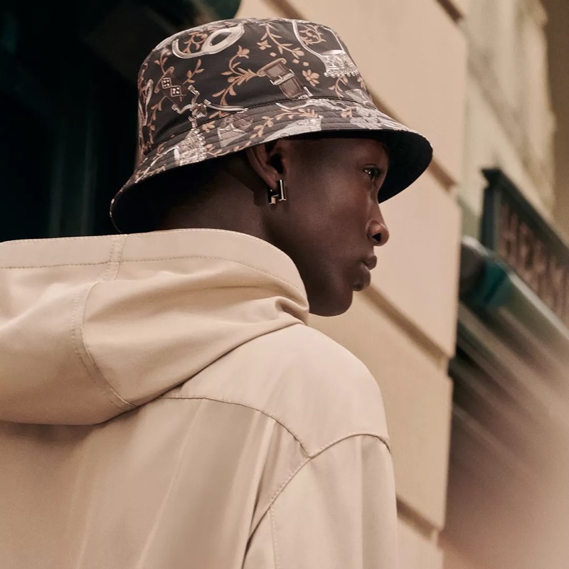 Hermès delivers dueling statements with a printed bucket hat and its Habascule single earring. 