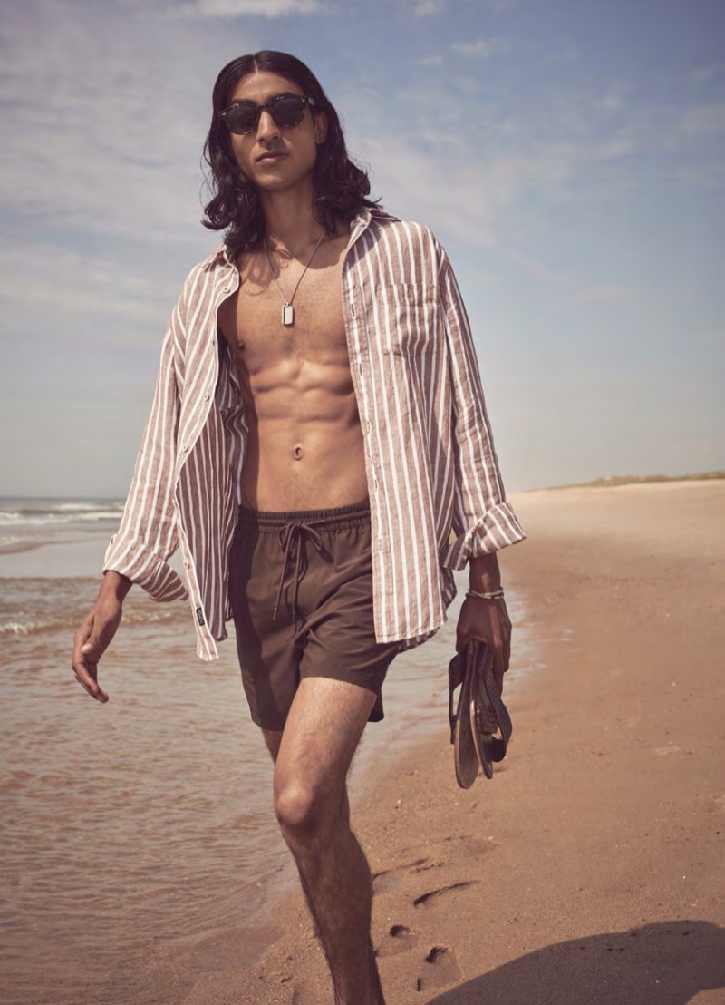 Hitting the beach, Adarsh Jaikarran wears a striped Irish linen shirt with swim shorts.