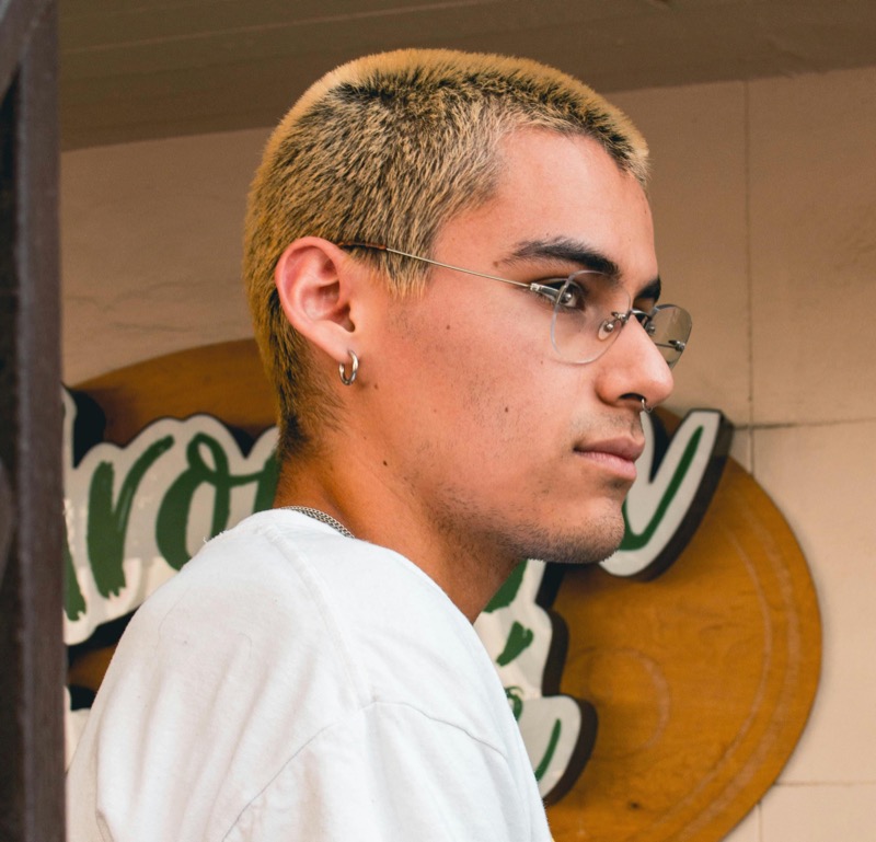 The dyed blonde buzz cut offers a bold, modern edge, perfectly pairing high-impact color with minimal maintenance.