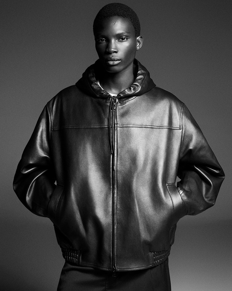 Embracing a modern cool, Dara Gueye wears a leather hooded jacket from COS’ fall-winter 2024 collection. 