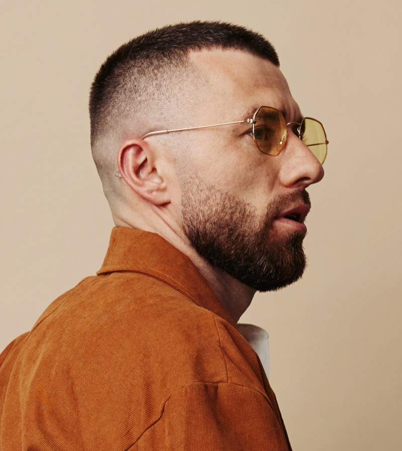 The brush cut’s uniform length is amplified by the sharp precision of a razor fade. 