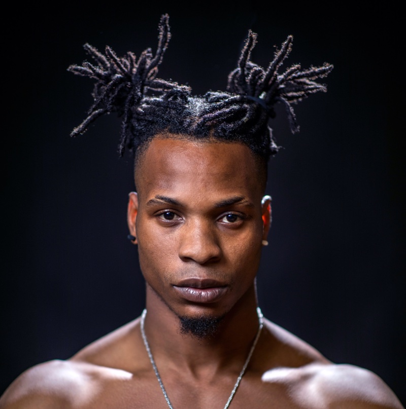 Dreads paired with a temple fade sharpen the overall style.