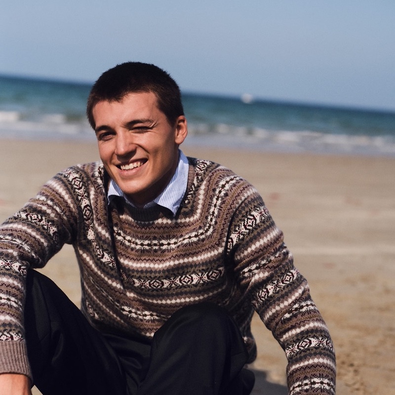 Taking to the beach, Casper Williams sports a striped Oxford shirt with a fair isle sweater from J.Crew.