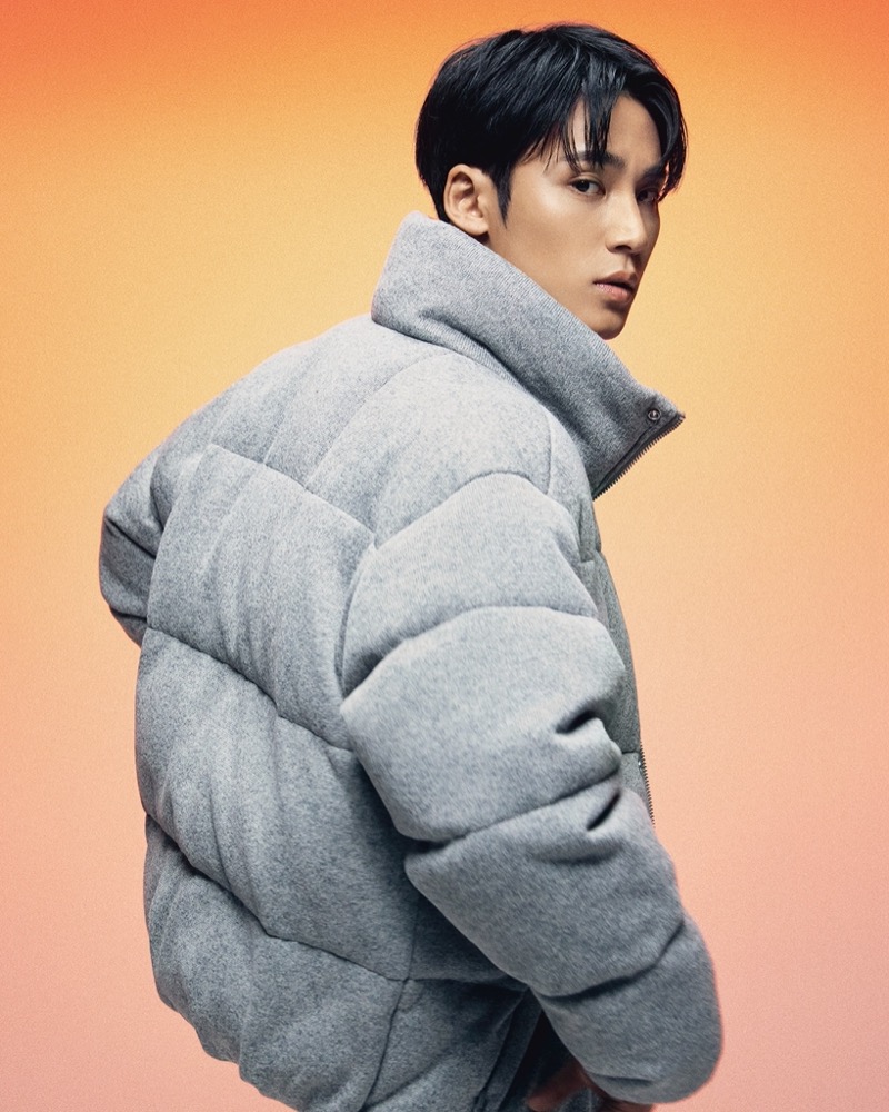 Embracing cold-weather style, MINGYU wears a heather grey down jacket from Calvin Klein.