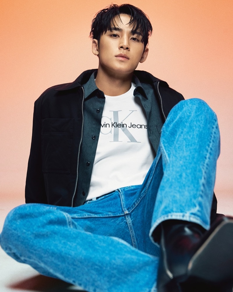 MINGYU of SEVENTEEN is a laid-back vision in a Calvin Klein shirt jacket and jeans.