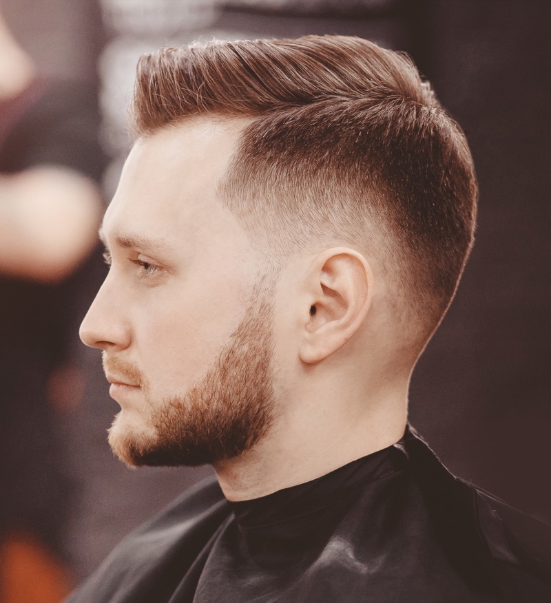 The side part with a burst fade brings a sleek, contemporary touch to a time-honored classic.