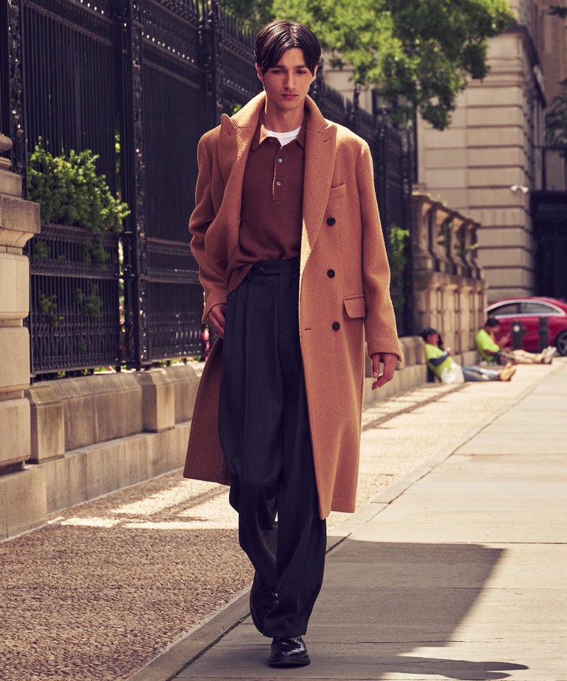 Rubuen Bilan-Carroll wears Todd Snyder’s Italian peak lapel wool topcoat with a cashmere polo and Wythe pleated trousers.